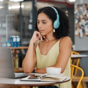 A lady listening to client issues on video call through headphones